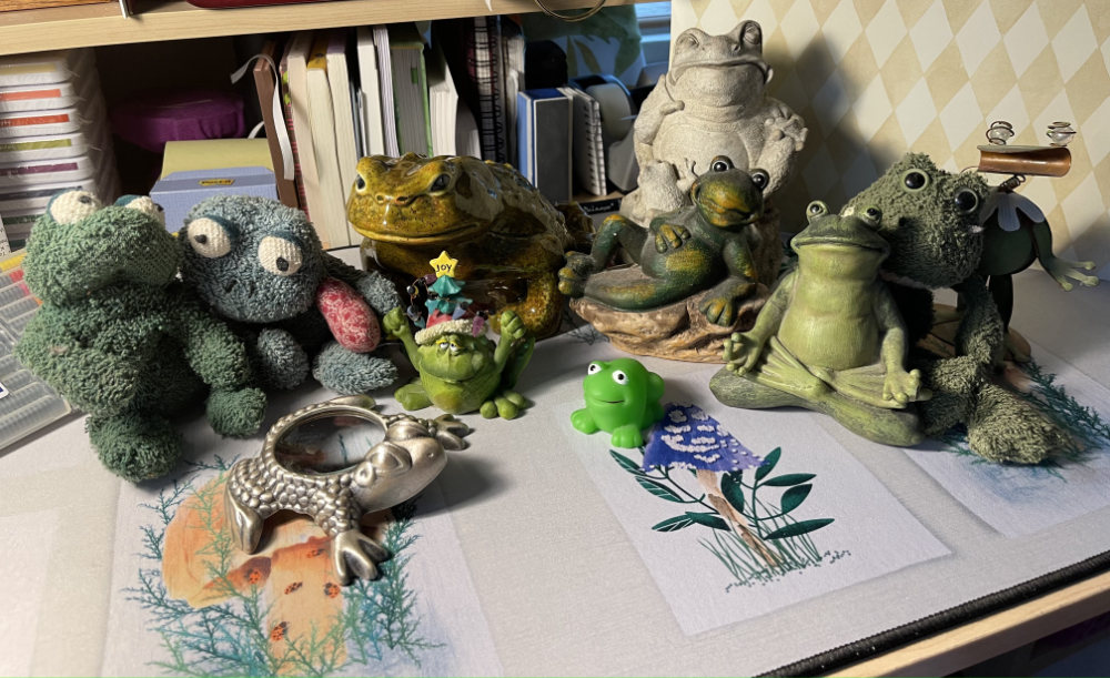 a group of stuffed, sculpted, plastic, ceramic frogs of all sizes