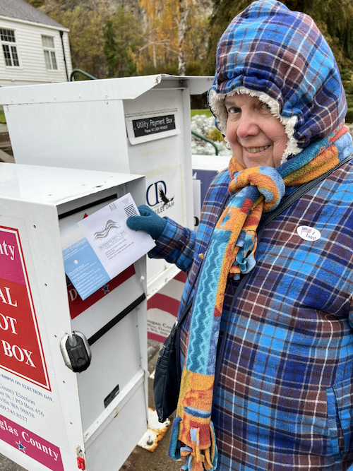 me, a senior woman, bundled up for windy, rainy weather, voted.