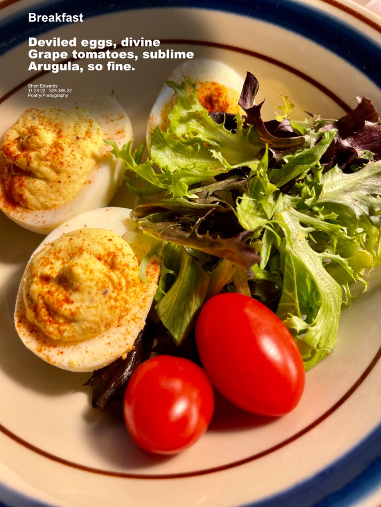 breakfast: deviled eggs, grape tomatoes, arugula on a tan plate with navy band around edge 