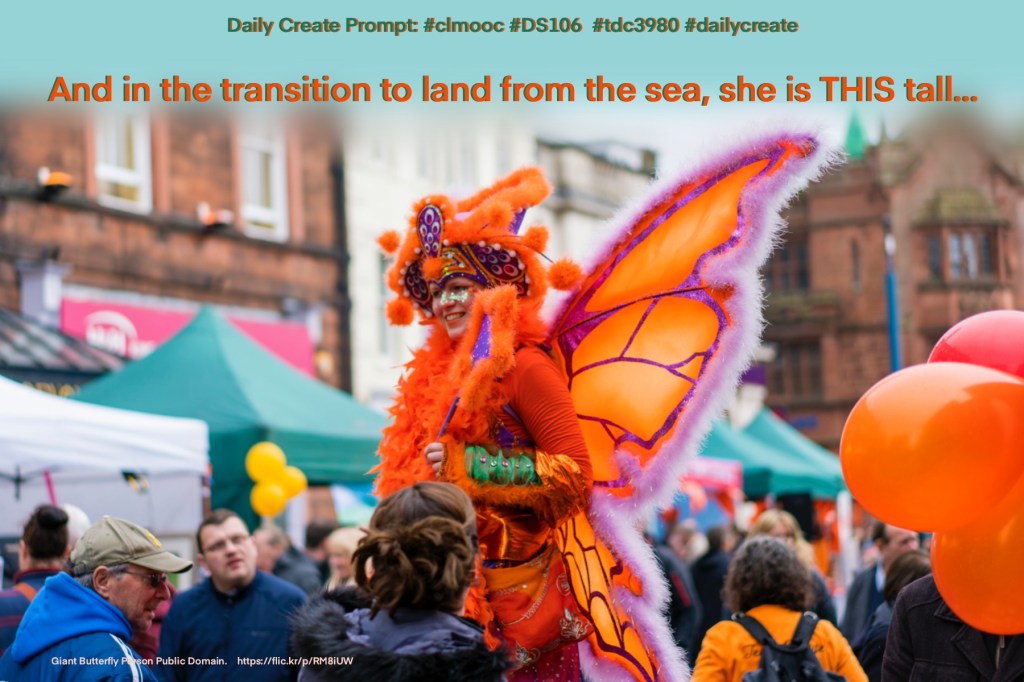 Festive woman dressed as orange butterfly towers above the crowd in the streets