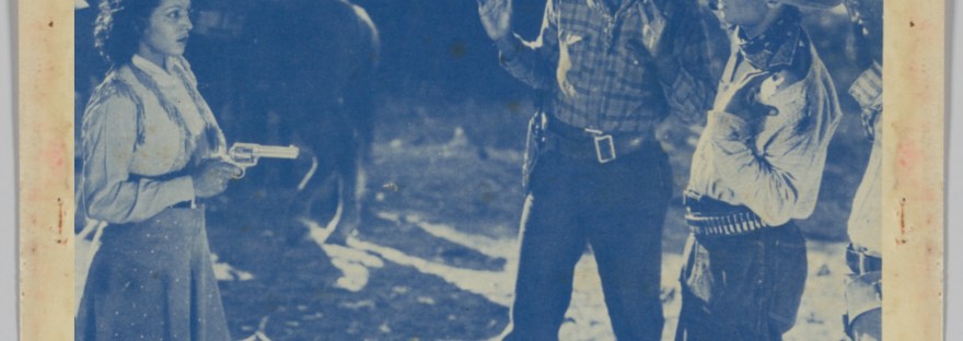 black and white image of a woman pointing a pistol at three men, wearing cowboy hats, bandanas, and hip holsters
