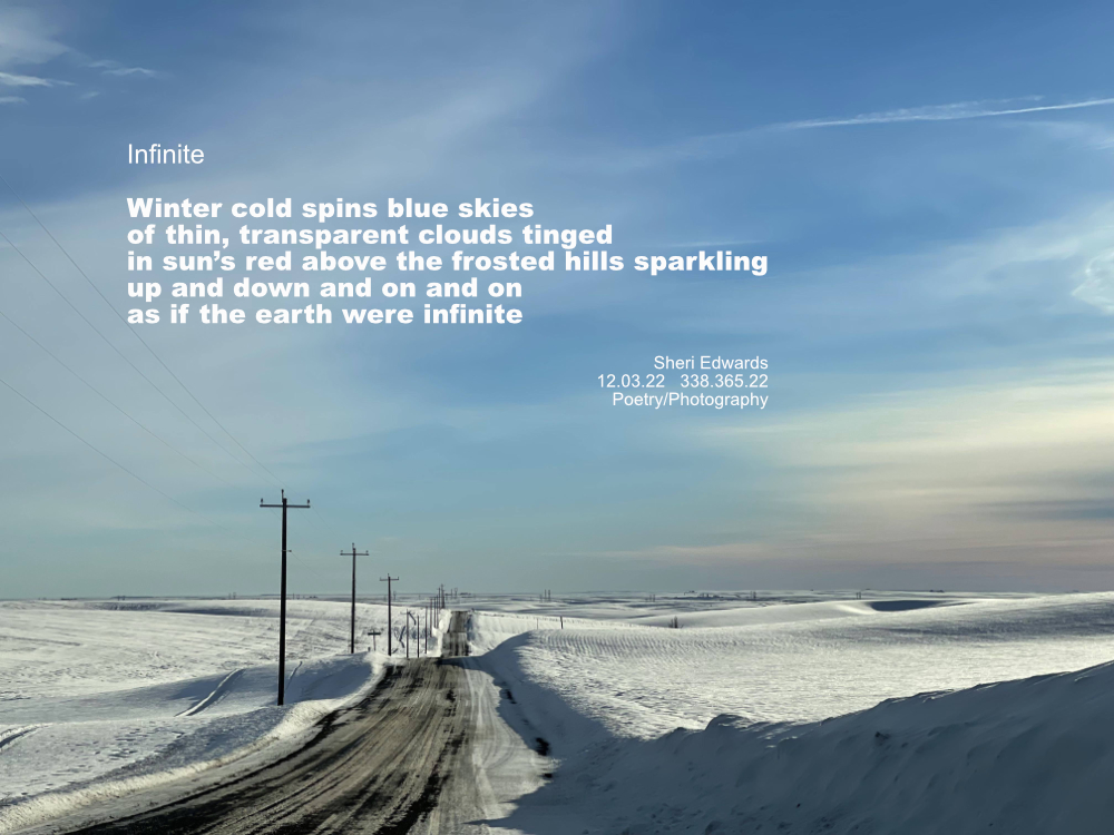 hilly countryside and road covered in snow with a red tint to thin clouds