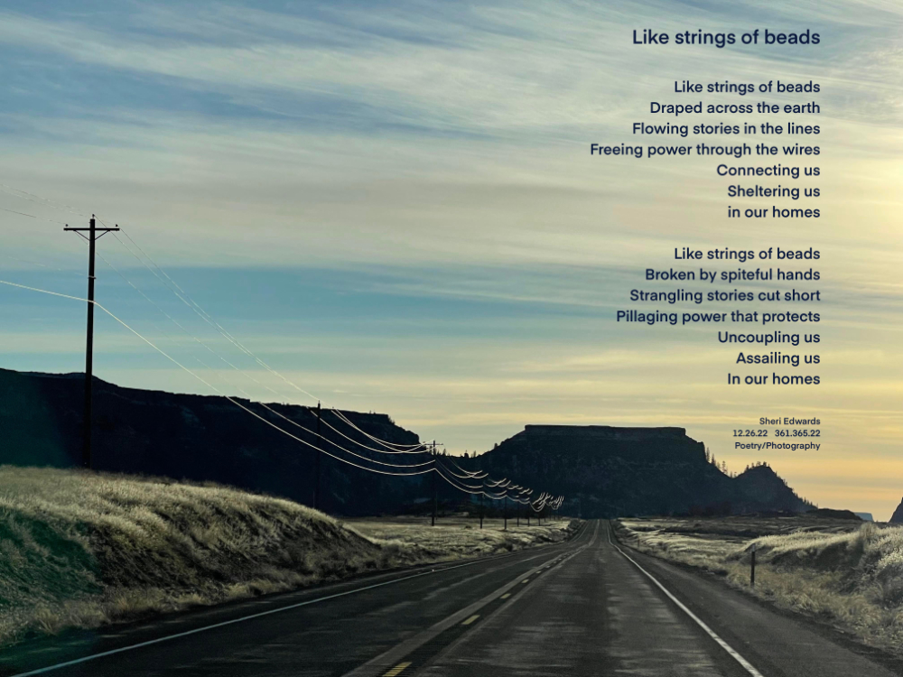 Frosty, winter day with ice on the wires looping along the highway beneath streaming clouds in the blue sky