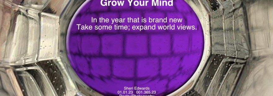 view of inside of twelve-sided glass held in one’s hand over a white keyboard with a purple center with the poem