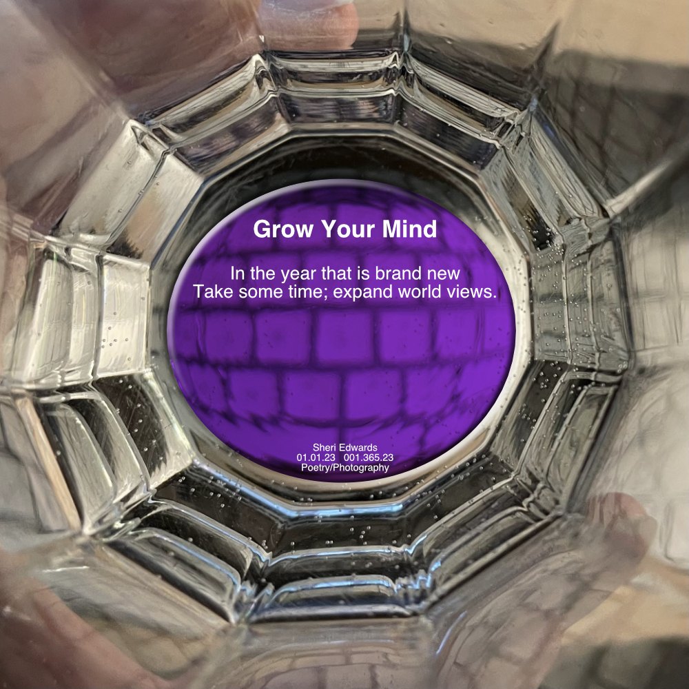 view of inside of twelve-sided glass held in one’s hand over a white keyboard with a purple center with the poem