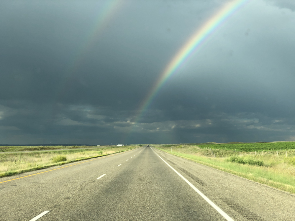 double rainbow in dark, stormy sky under the Big Sky of Montana's highways