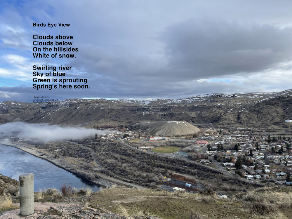 overlooking town of Coulee Dam during a cloudy day with bright blue sky peeking through and clouds below above the Columbia River