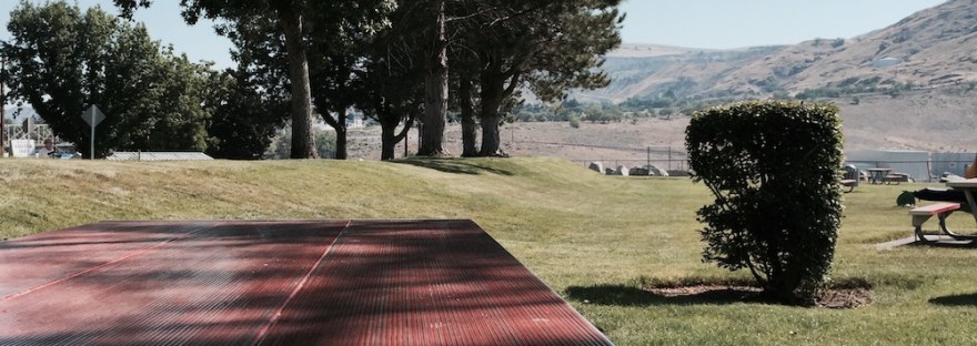 toy model car left on red picnic table in park