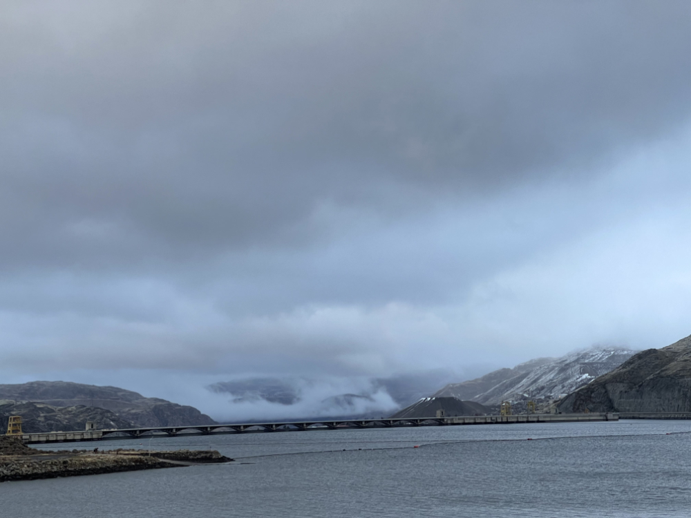 blue, silver, and grey clouds flow across the hills around Grand Coulee Dam