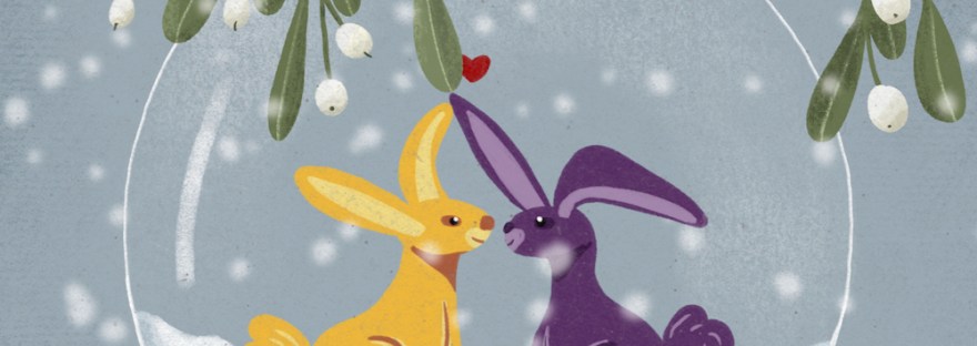 birthday card with two rabbits in clear ornament topped with mistletoe and red ribbon in snowfall