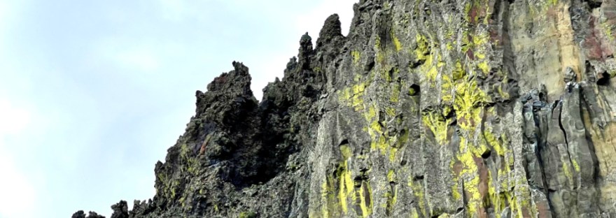Ancient basalt columns millions of years old still stand hundreds of feet tall in a jagged line against the sky in Dry Coulee of Eastern Washington State.