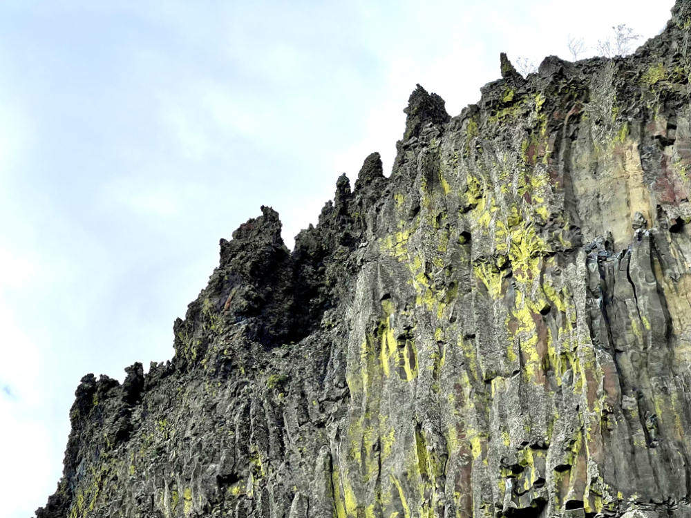 Ancient basalt columns millions of years old still stand hundreds of feet tall in a jagged line against the sky in Dry Coulee of Eastern Washington State.
