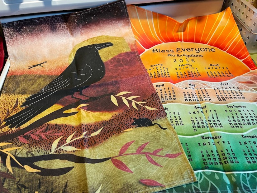 two tea towels from Spoonflower: one folk / abstract style of raven; another 2025 calendar in silk painting/ wax resist style /by Sheri42