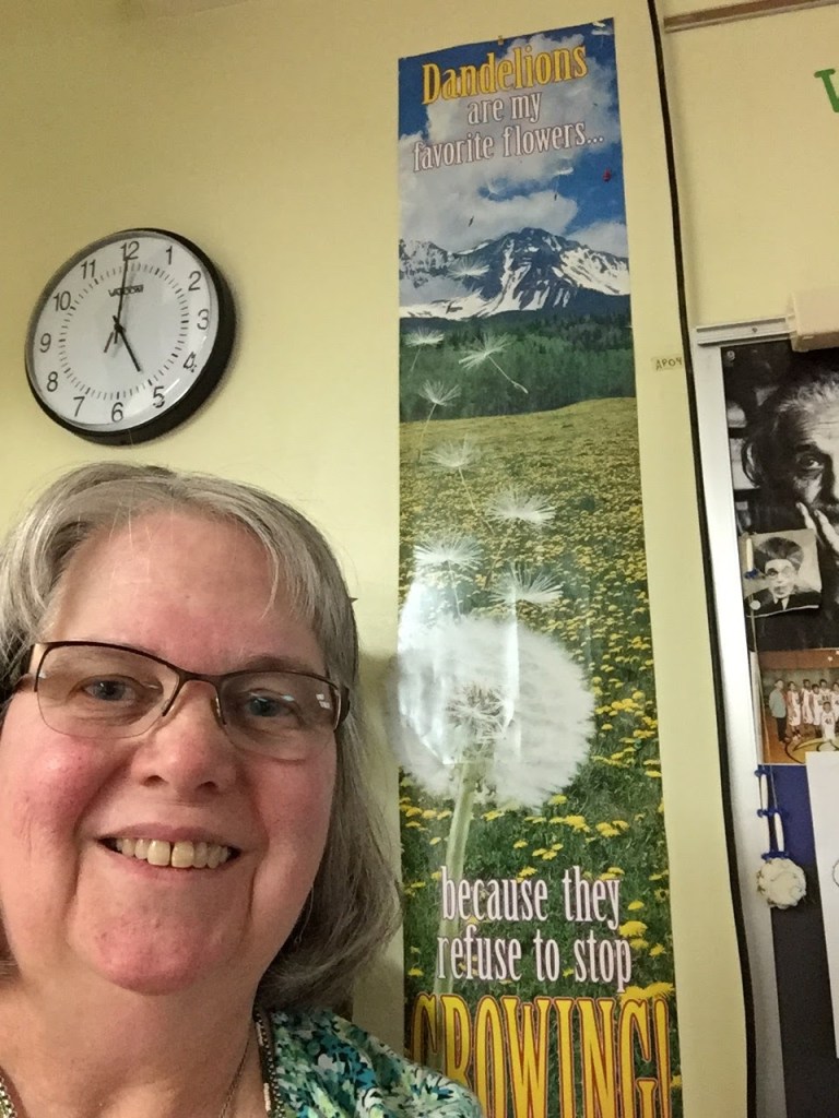 Ms Edwards in her classroom in on Feb 24, 2016 by the "Dandelions are my favorite flowers...because they refuse to stop growing" poster