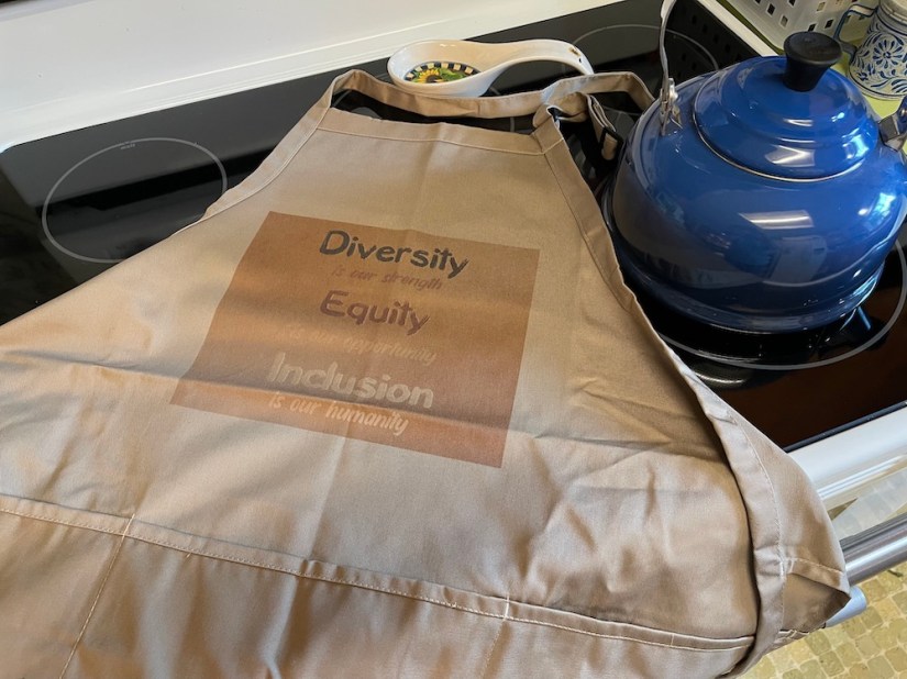 Diversity is our strength; equity is our opportunity; inclusion is our humanity-- on a pocketed apron; Sheri42