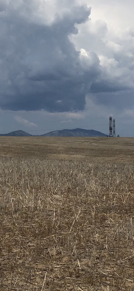 harvested wheat field with mountains and communication tower in background nanowrimo nanowrimo25