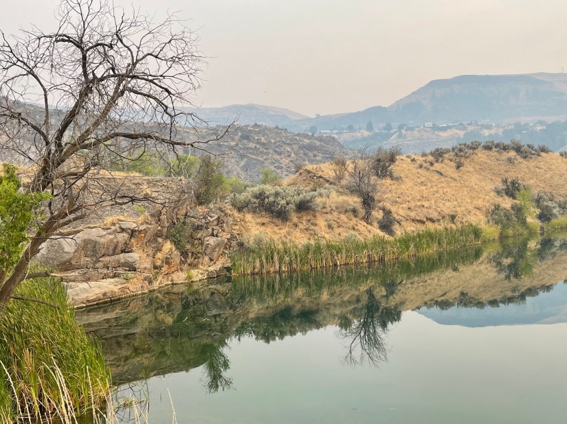 Even the reflection in Crescent Lake in Grand Coulee shows the smoke from Washington State wildfires during calm weather.